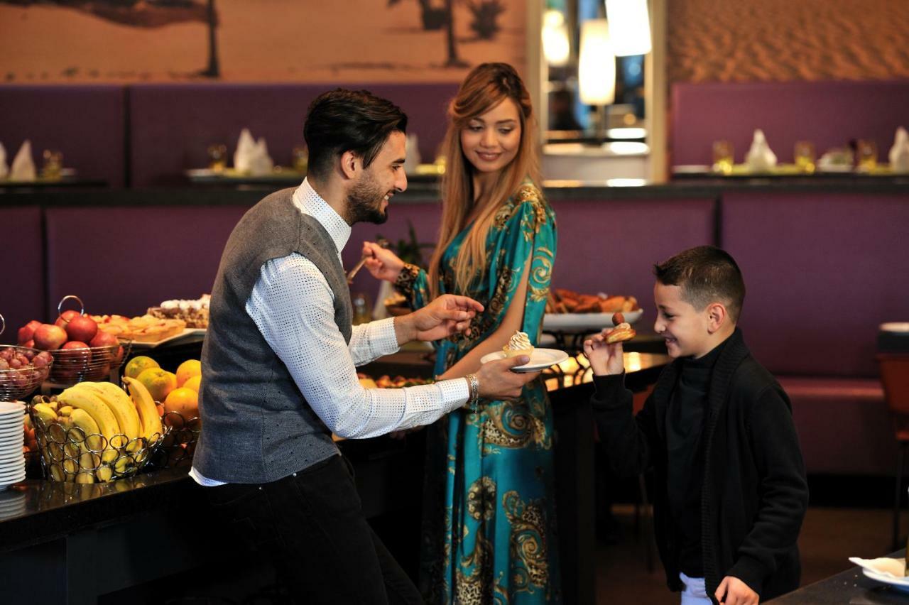 Hotel Mercure Alger Aéroport Dar el Beïda Esterno foto A waiter serving a family